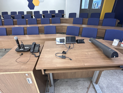 Top-down view of podium. Microphone and telephone on the left; touch panel control system at center; document camera on the right.
