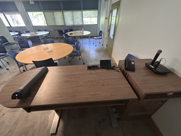 Top-down view of podium. Document camera on the left; telephone and touch panel control system at center; microphone on the right.