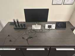 Top-down view of podium. Microphones on the left; room PC at center; touch panel control system on the right.