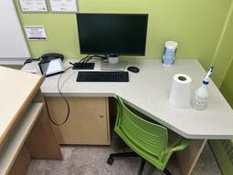 Image of the podium at the front of the classroom. This podium is not movable or height adjustable. A phone is located on the left side of the podium. This podium is not accessible