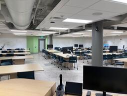 Instructor’s view while standing at the podium. There are whiteboards on every wall and projectors can project onto the boards. The classroom is accessible for instructors.