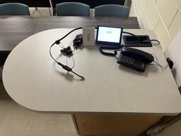 Top down view of the instructor’s podium. The podium is equipped with microphones and a telephone.