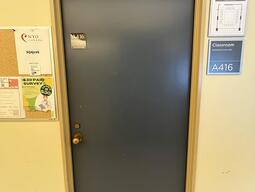 The entryway of room A416 in Mackintosh Corry Hall is a blue door with a doorknob on the left side.