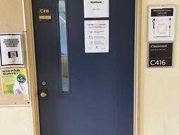The entryway of room C416 in Mackintosh Corry Hall is a blue door with a doorknob on the left side.