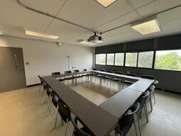 View of the classroom from the front of the room. There are multiple tables and chairs for students, that can be arranged according to the instructor’s preference. This classroom is accessible for instructors.