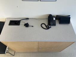 Top-down view of the podium. The podium is equipped with a set of connection cords to present media in the classroom.
