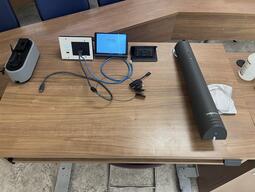 Top-down view of the instructor’s podium. The podium is equipped with a document camera, lecture capture as well as a set of microphones. The podium is height adjustable.