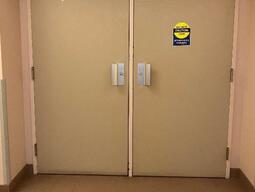 The entryway of room 202 in Robert Sutherland Hall is a pair of white doors with handles in the middle of the double doors.