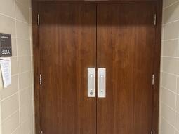 The entryway of room 301A in Stirling Hall is a double door with two pull handles in the center. The door does not have an automatic operator.
