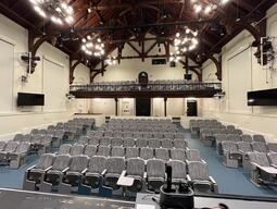 View of the classroom from the instructor’s podium. There are multiple rows of chairs, across two levels, facing the front of the room. This classroom is tiered for access to the middle and back areas of the room. This classroom is accessible for instructors.