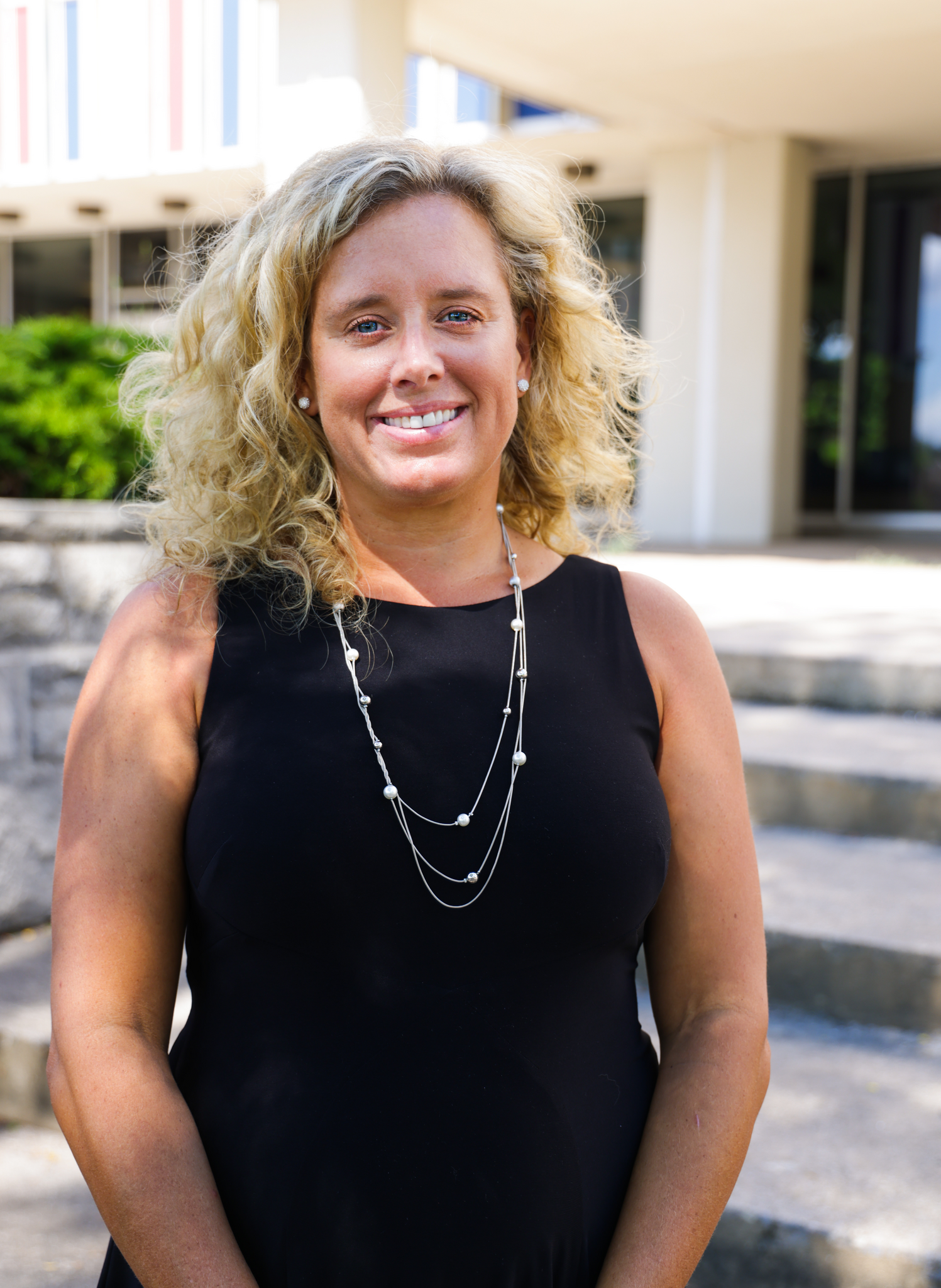 Woman in a black shirt standing in front of stone steps