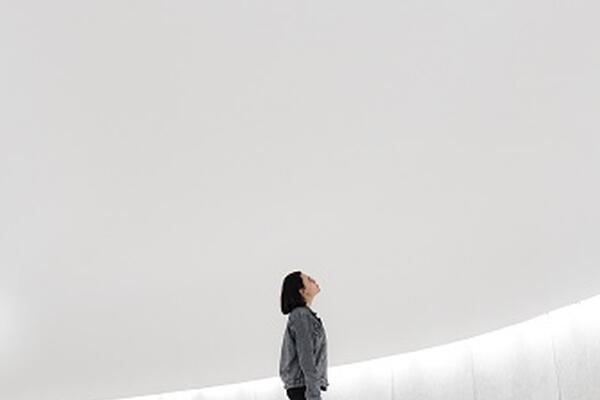 woman looking up at a large white ceiling