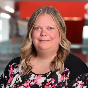 Headshot of Aimee Burtch wearing a pink and black shirt