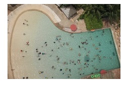 "large pool with a number of people in it photographed from above"