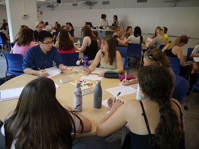 "Group of students working together at a round table in Mackintosh-Corry Hall, Room D201"