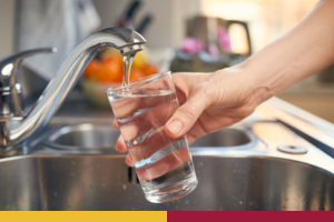 A person filling a glass with tap water. 