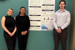 Students standing beside poster