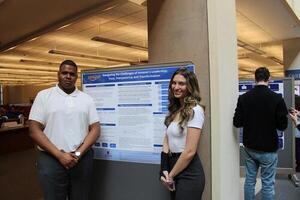 Students standing beside poster