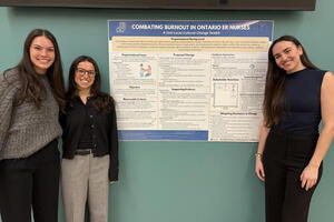 Students standing beside poster