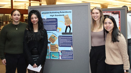 Students standing beside poster