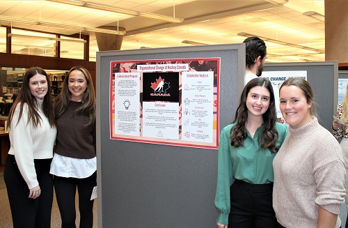 Students standing beside poster