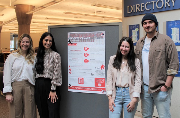 Students standing beside poster