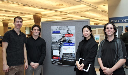 Students standing beside poster