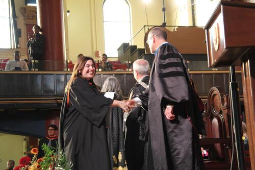 MIR grad walking across stage at ceremony