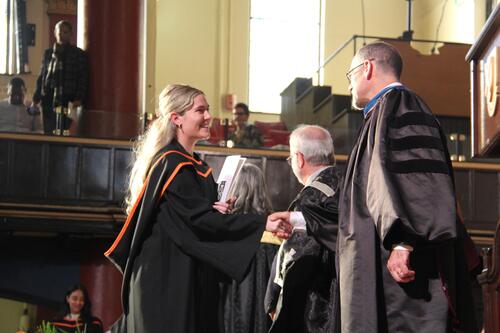 MIR grad walking across stage at ceremony