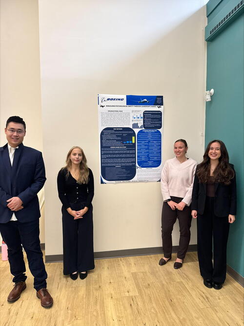 Students standing beside poster