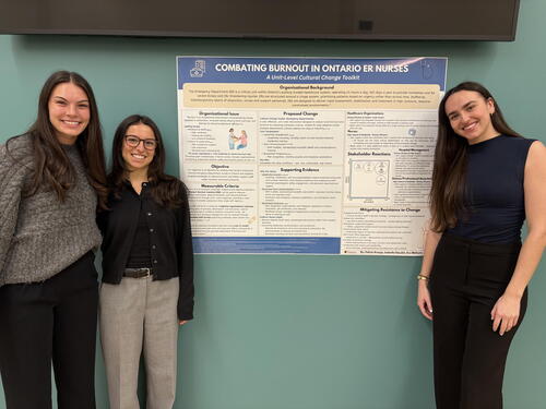 Students standing beside poster