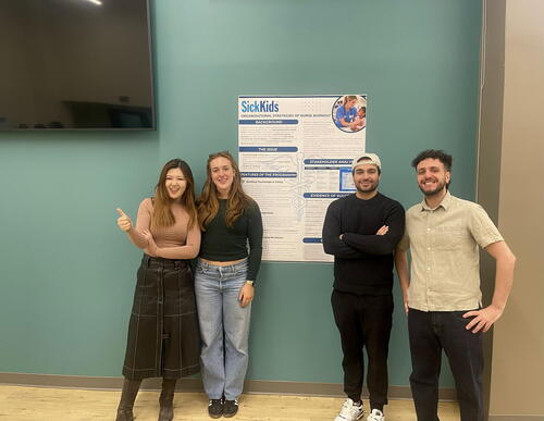 Students standing beside poster