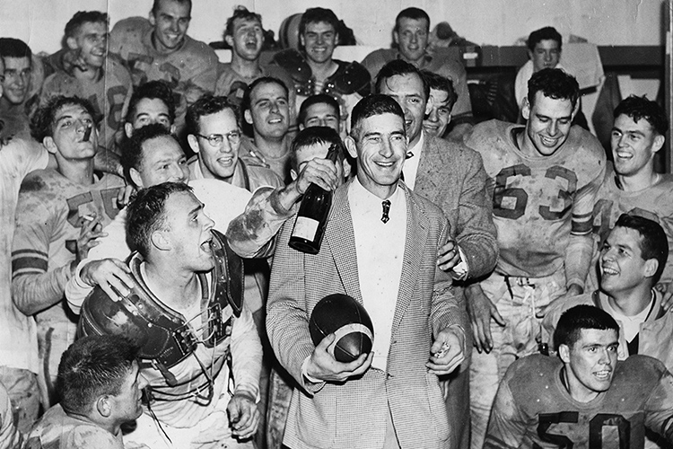 [Coach Tindall and his players in the locker room after winning the 1955 intercollegiate championship]