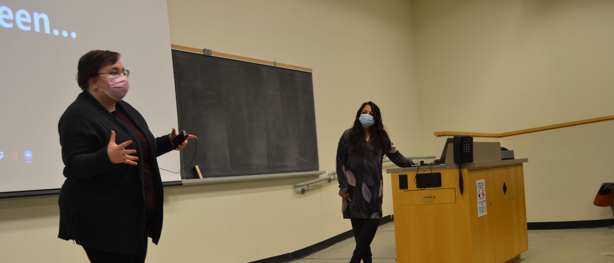 photo of grad student and prof giving lecture 