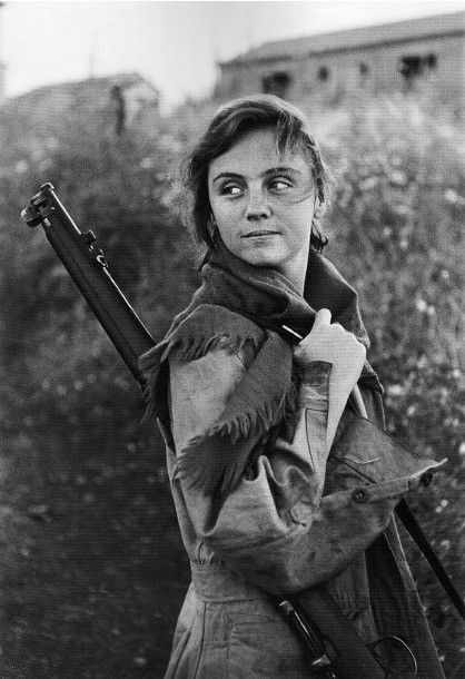 Woman carrying a gun over her shoulder.