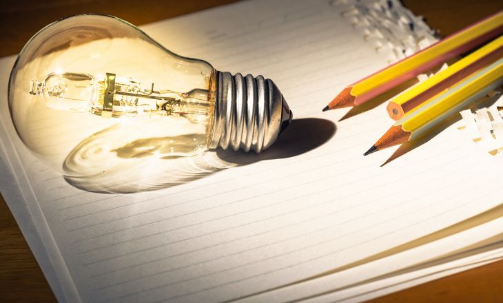 light bulb on paper with pencils 