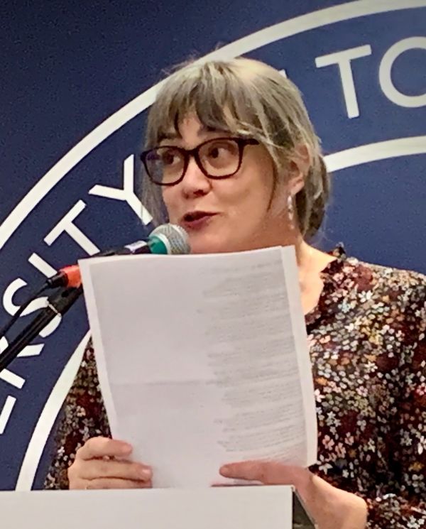 photo of heather reading at a podium 