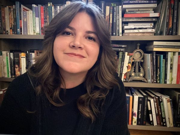Picture of Emma in front of a bookshelf.