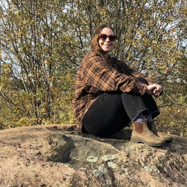 photo of Sara sitting on a rock 