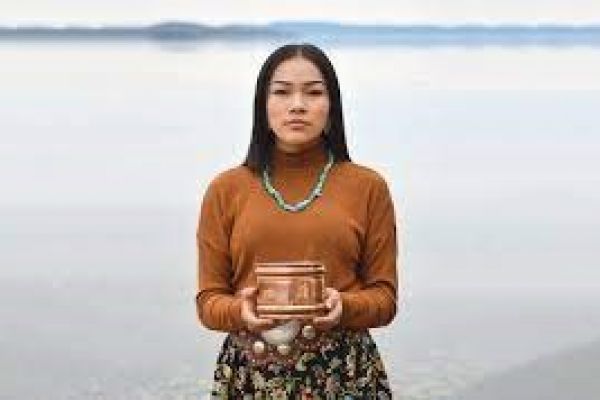 Indigenous woman holding a box