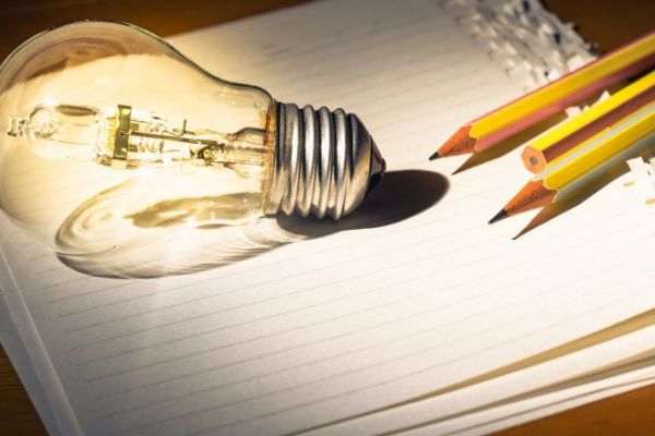 light bulb on paper with pencils 