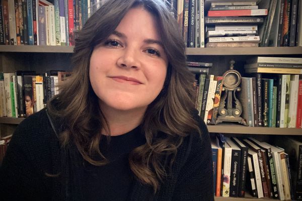 Picture of Emma in front of a bookshelf.