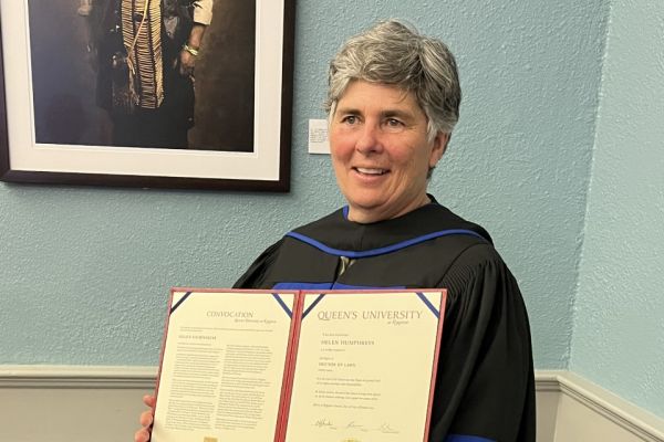 photo of Helen holding her doctorate 