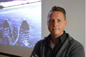 sam standing in front of an image of skates