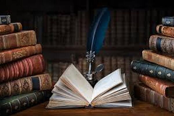 image of stacks of old books with one book open in the center