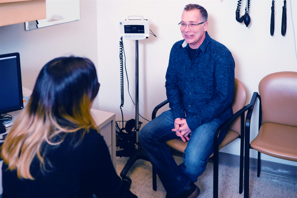 Patient smiling at family doctor. Links to Data Access Fees page.