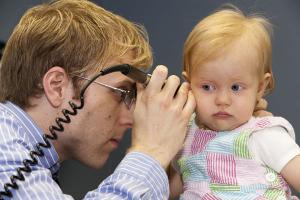 Doctor checking a child's ear canal.