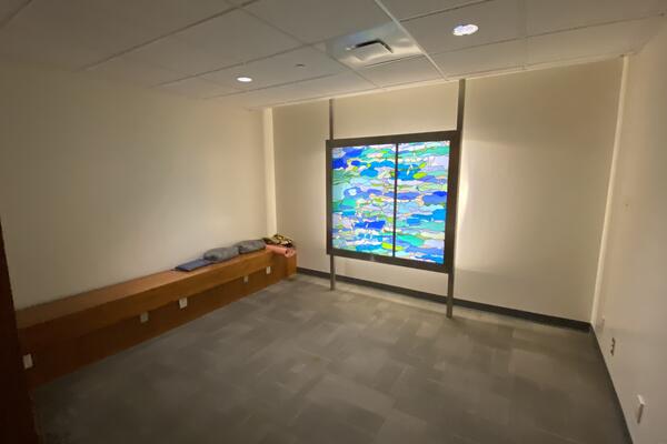 Open space with low bench and stained glass decoration at Goodes Hall. Go to campus map