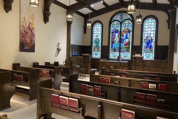 Pews facing multicoloured stained glass windows at Morgan Memorial Chapel. Go to campus map.