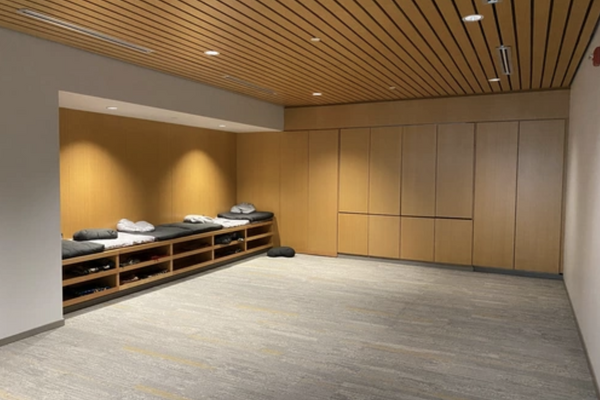 A soft-lit carpeted prayer room with wood walls
